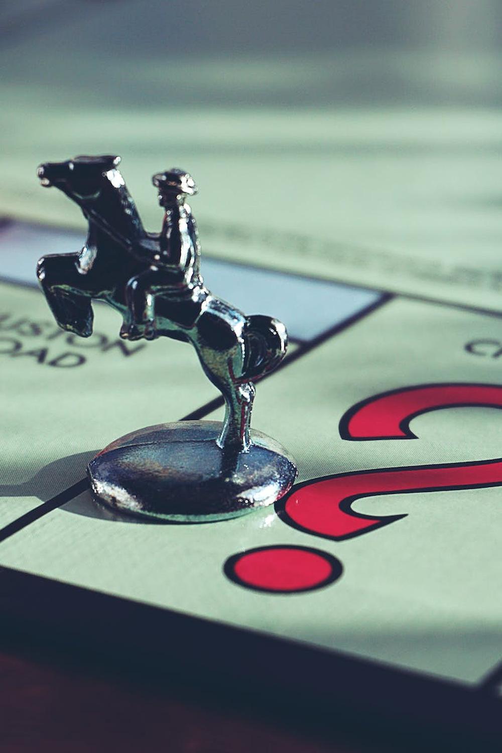 horse_miniature_toy_on_top_of_monopoly_board_game